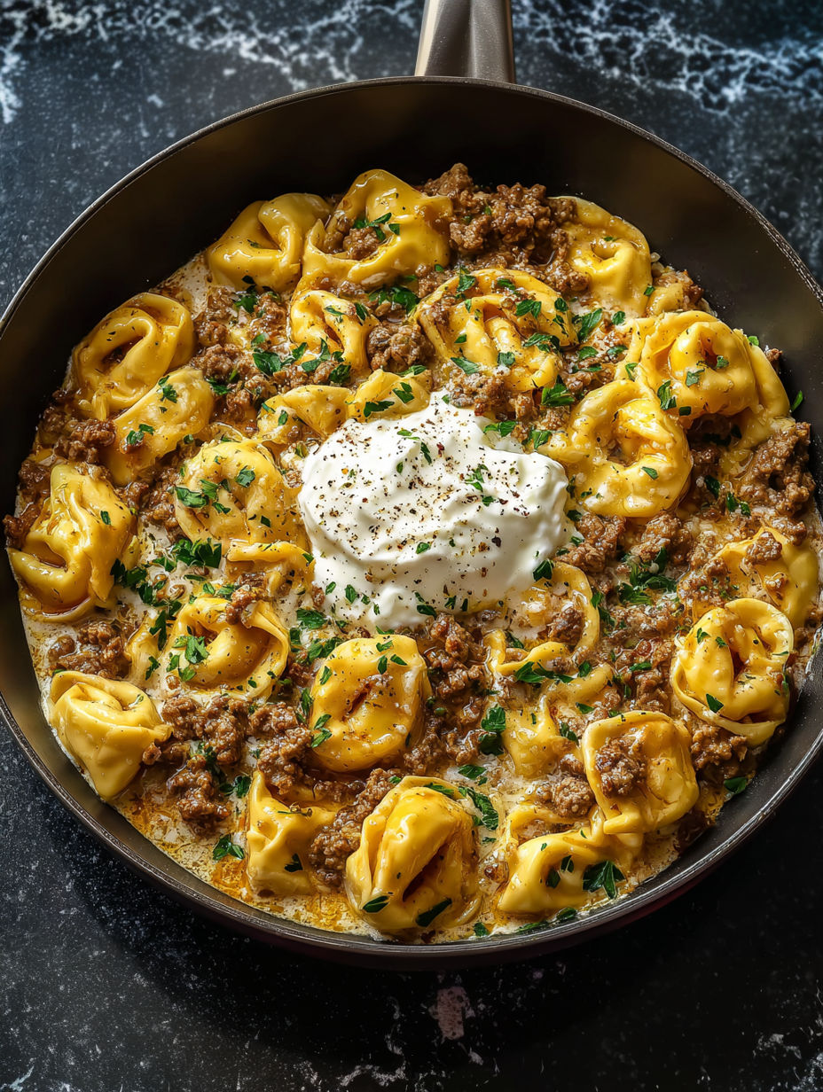 A bowl of pasta with meat and cheese.