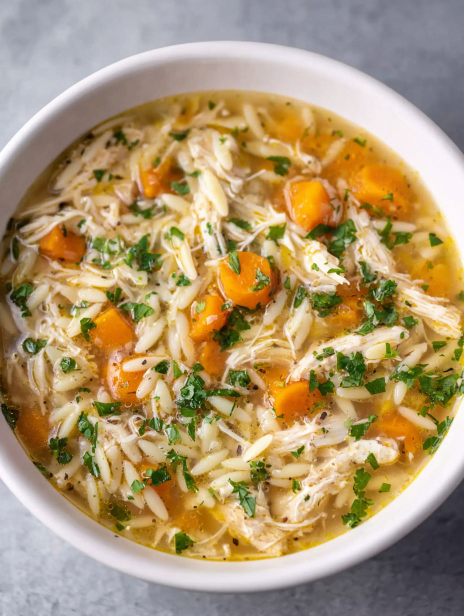 A bowl of soup with chicken and vegetables.