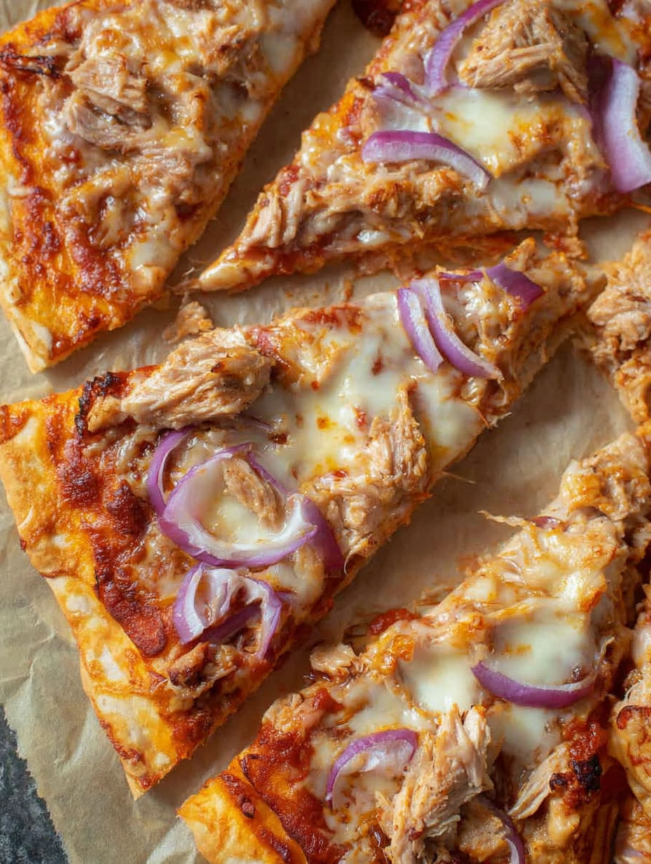 A slice of pizza with onions and meat on it.