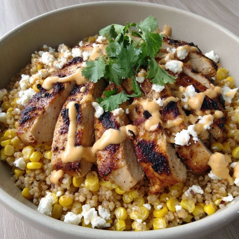 A bowl of chicken rice with corn and cheese.