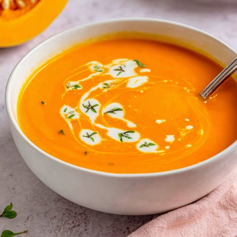 A bowl of creamy soup with a spoon in it.