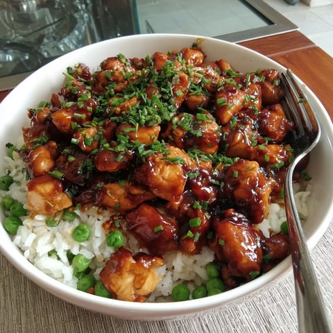 A bowl of honey glazed chicken with rice.
