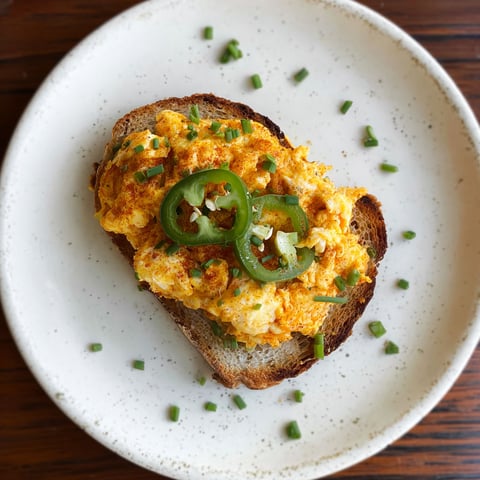 A slice of toast with egg salad on it.