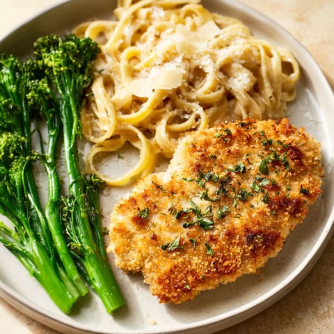 A plate of food with Parmesan-crusted chicken and broccoli.