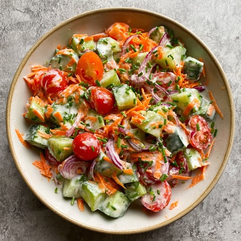 A bowl of vegetables with a salad dressing.