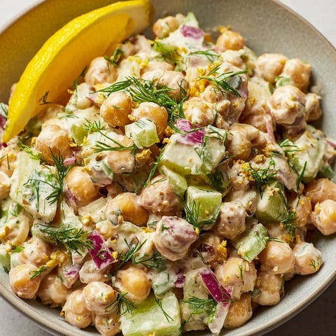 A bowl of salad with chickpeas, lemon, and dill.