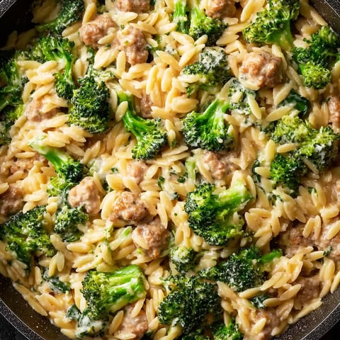 A bowl of chicken and broccoli orzo.